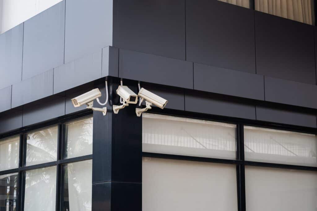 Three white security systems installed outside of an office building